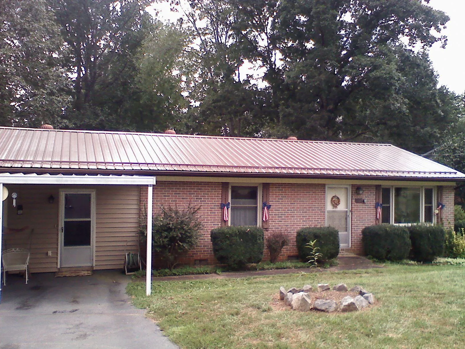 Bronze metal roof and carport on a brick ranch home — Roof Repair work by our crew in Carleton